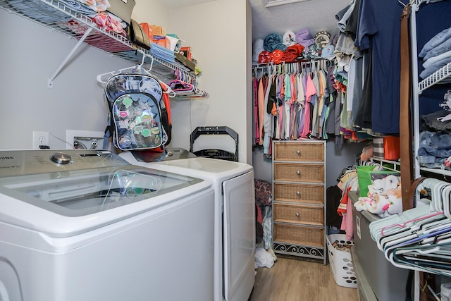 clothes washing area featuring separate washer and dryer, laundry area, and wood finished floors