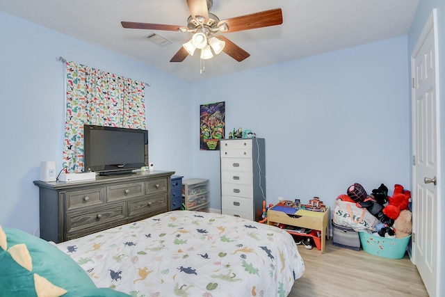 bedroom featuring wood finished floors, ceiling fan, and visible vents