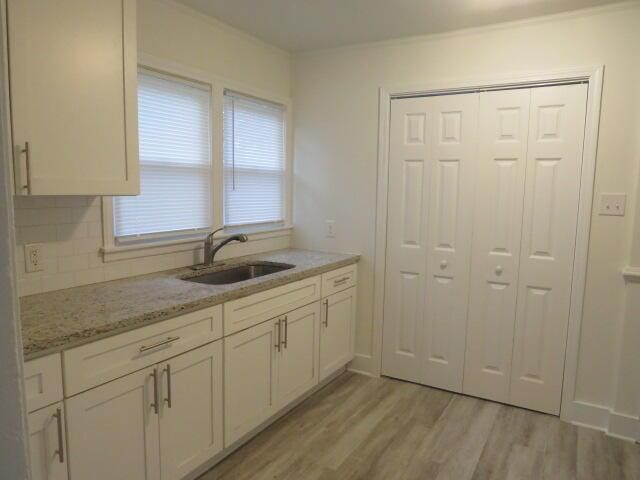 2072 Battle Row, Augusta, GA 30904 - kitchen featuring light wood-type flooring, white cabinetry, light stone countertops, and decorative backsplash