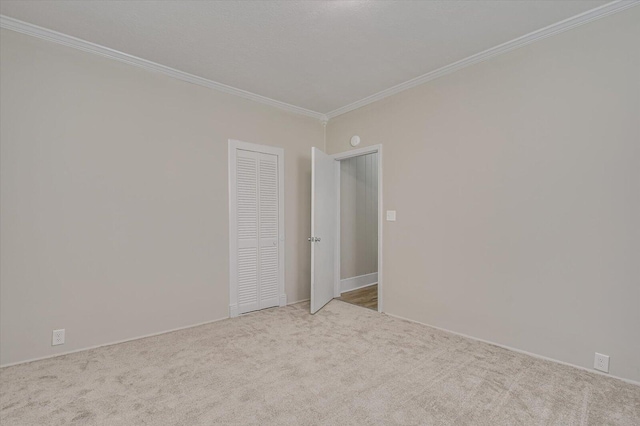 empty room featuring carpet flooring, baseboards, and ornamental molding