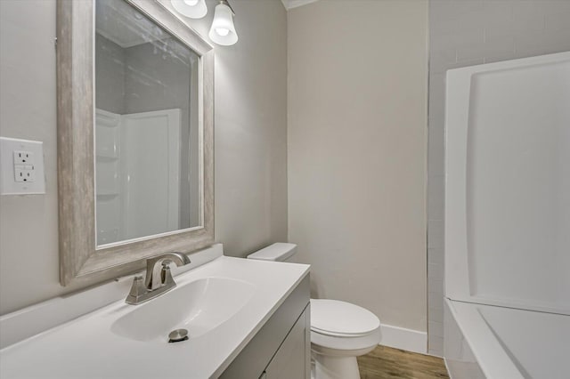 bathroom with toilet, vanity, wood finished floors, and walk in shower