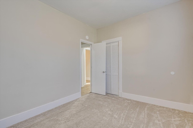 empty room with light colored carpet and baseboards
