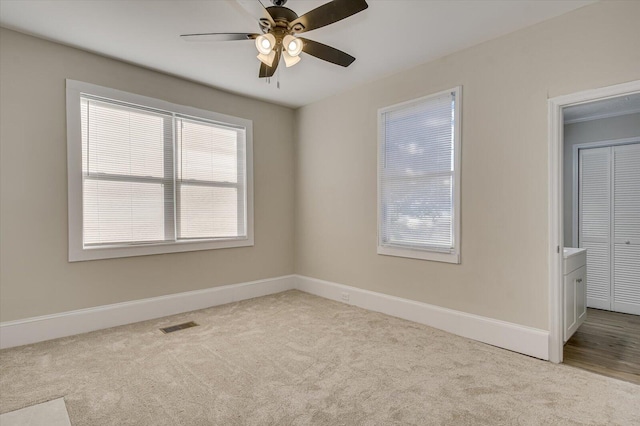 unfurnished room with visible vents, ceiling fan, carpet floors, and a healthy amount of sunlight