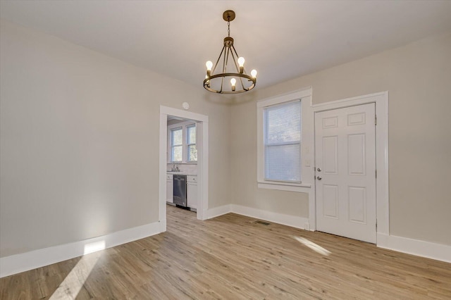interior space featuring a chandelier, baseboards, and light wood-style flooring