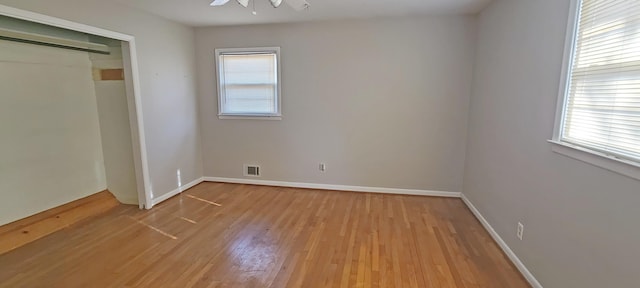 unfurnished bedroom with ceiling fan, light wood-type flooring, and a closet