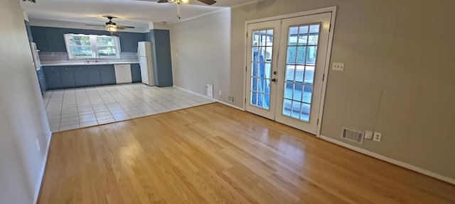 kitchen featuring sink, decorative backsplash, white appliances, light wood-type flooring, and french doors