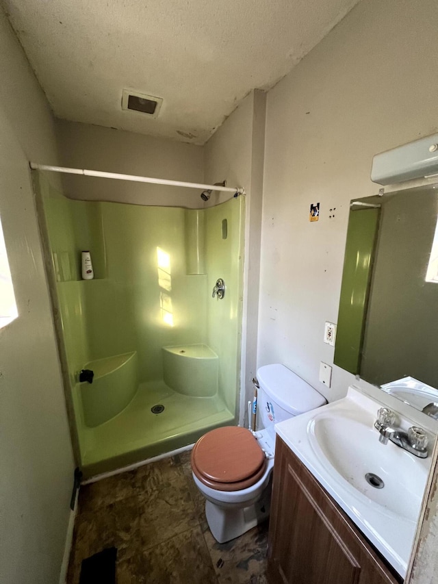 bathroom featuring vanity, toilet, a shower, and a textured ceiling