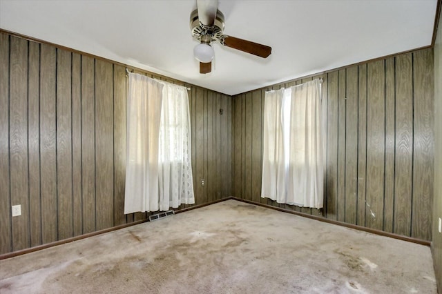 2514 Lumpkin Rd, Augusta, GA 30906 - carpeted empty room featuring a wealth of natural light, wooden walls, visible vents, and ceiling fan