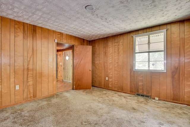 2514 Lumpkin Rd, Augusta, GA 30906 - empty room featuring wood walls, visible vents, a textured ceiling, and carpet floors