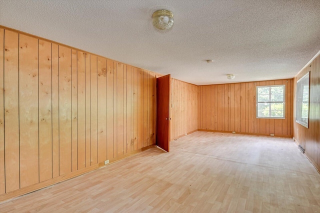 2514 Lumpkin Rd, Augusta, GA 30906 - spare room featuring wood walls, light wood-type flooring, and a textured ceiling