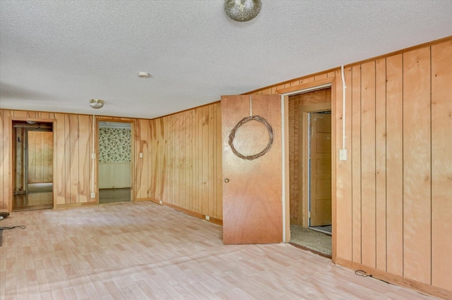 2514 Lumpkin Rd, Augusta, GA 30906 - unfurnished room featuring light wood-style flooring, a textured ceiling, wooden walls, and baseboards