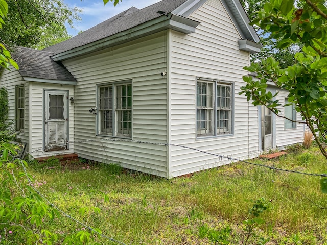 view of side of home featuring roof with shingles