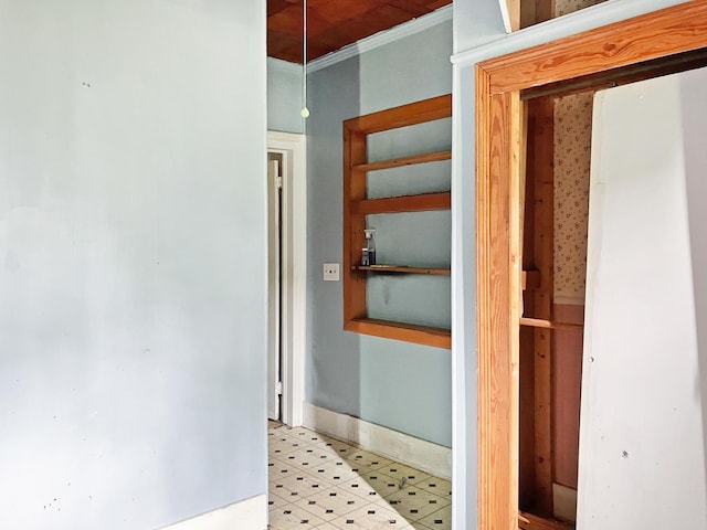 hall with light floors, baseboards, and ornamental molding