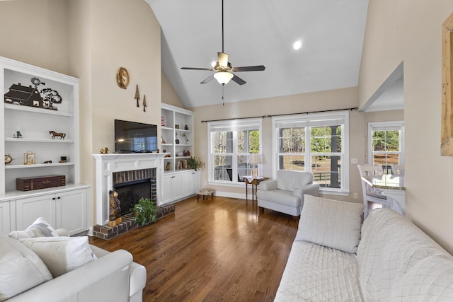 living area with ceiling fan, high vaulted ceiling, a fireplace, wood finished floors, and built in features