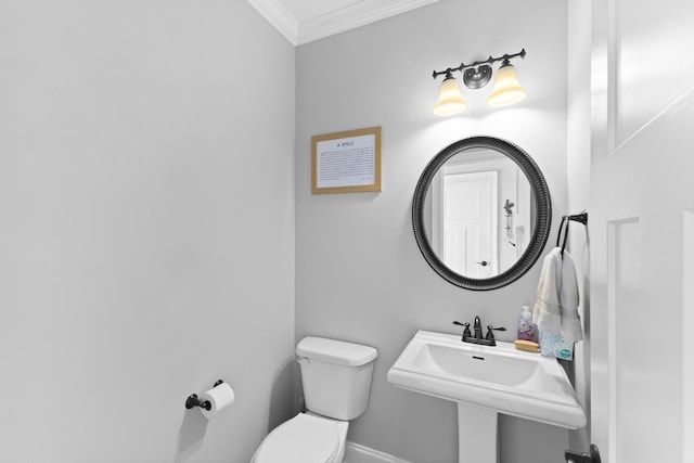 bathroom with baseboards, a sink, toilet, and crown molding