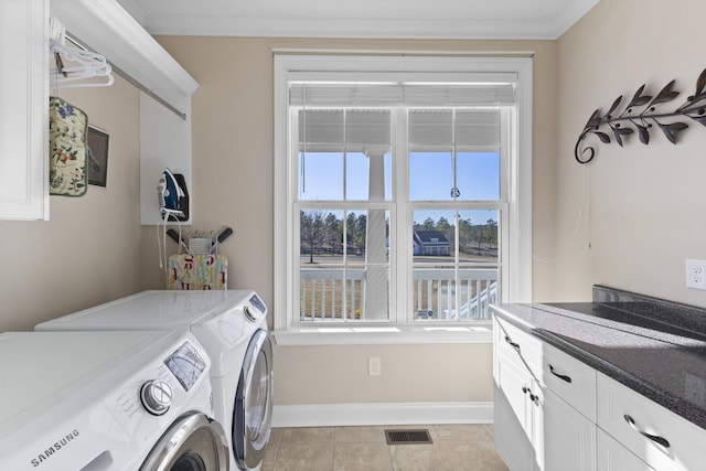 washroom featuring cabinet space, baseboards, ornamental molding, washing machine and dryer, and light tile patterned flooring