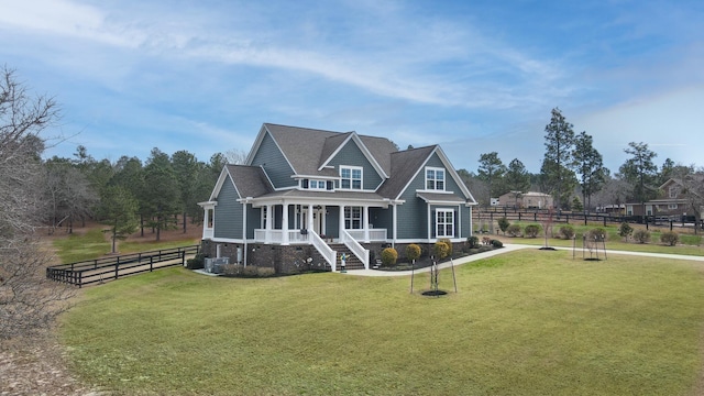 view of front of property featuring cooling unit, roof with shingles, fence, and a front lawn