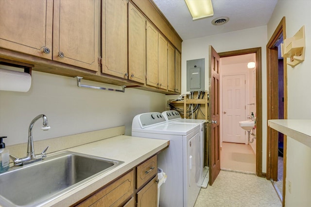 laundry room featuring electric panel, cabinets, sink, and washer and dryer