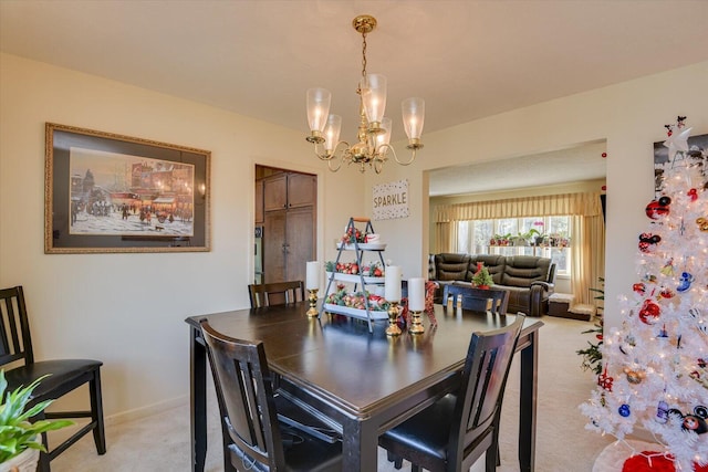 dining room featuring light carpet and an inviting chandelier