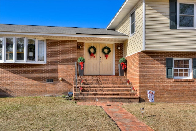 view of exterior entry with a yard