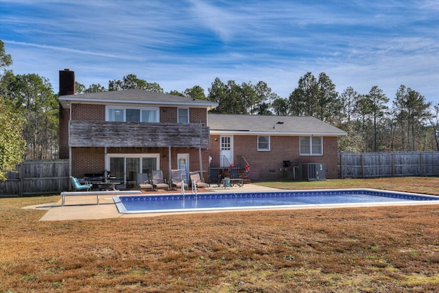 view of pool with a lawn, central AC, and a patio