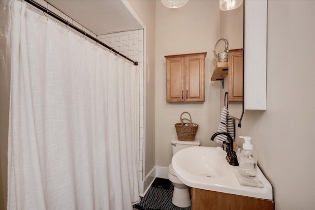 bathroom featuring a shower with shower curtain, a sink, and baseboards