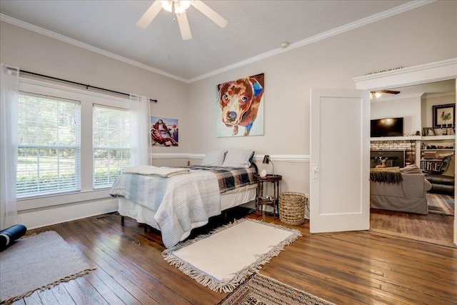 bedroom with crown molding, a fireplace, and dark wood-style flooring