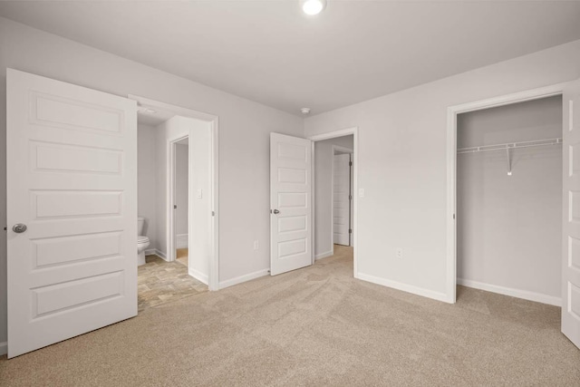 unfurnished bedroom with light colored carpet, connected bathroom, and a closet