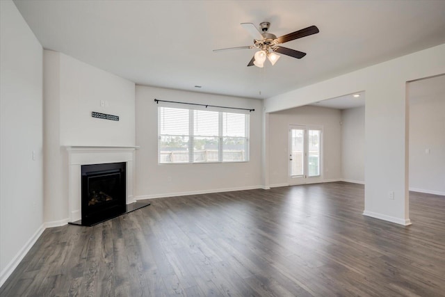 unfurnished living room featuring ceiling fan and dark hardwood / wood-style flooring