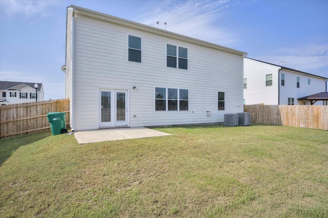 rear view of house featuring a lawn, central AC unit, and a patio