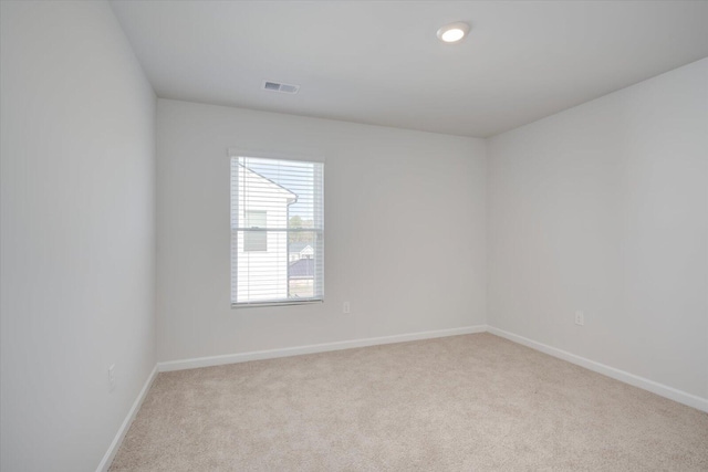 spare room featuring light carpet