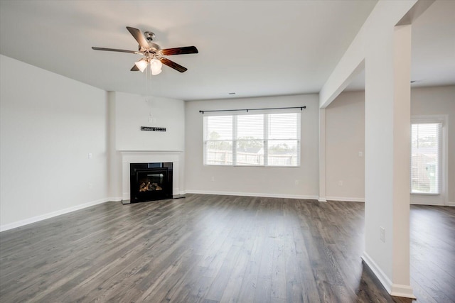 unfurnished living room featuring ceiling fan and dark wood-type flooring