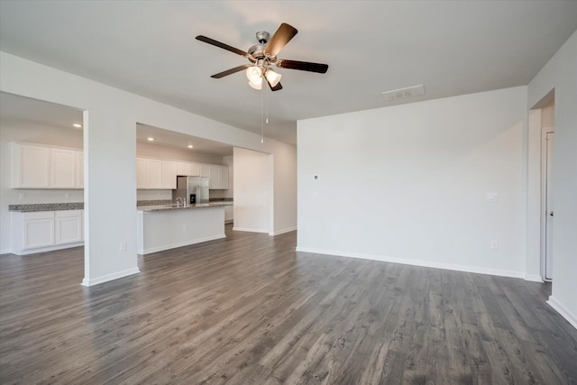 unfurnished living room featuring dark hardwood / wood-style flooring and ceiling fan