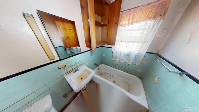 bathroom with tile walls, sink, and a bathing tub