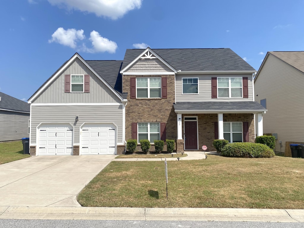 craftsman-style home featuring a garage and a front lawn