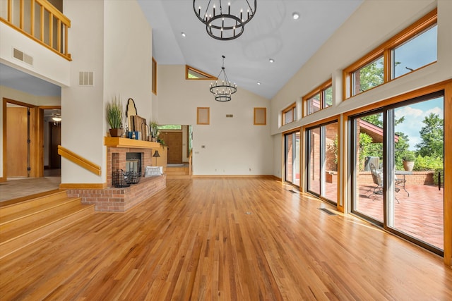 unfurnished living room with light hardwood / wood-style floors, a fireplace, and a high ceiling