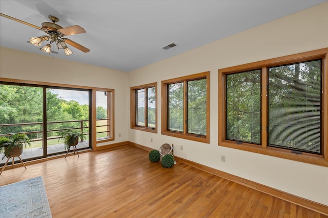 unfurnished sunroom with ceiling fan