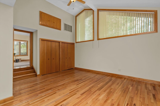 unfurnished room with ceiling fan, light hardwood / wood-style floors, and lofted ceiling