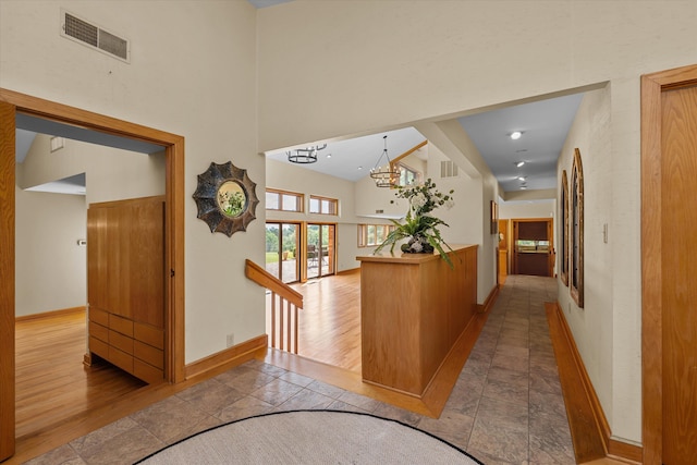 hallway featuring light tile patterned floors and an inviting chandelier