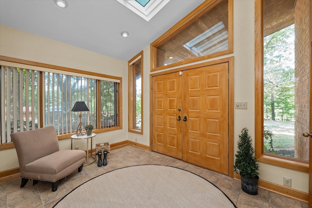 foyer entrance with vaulted ceiling with skylight