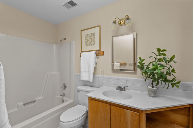 full bathroom featuring vanity, toilet, tile walls, and bathing tub / shower combination