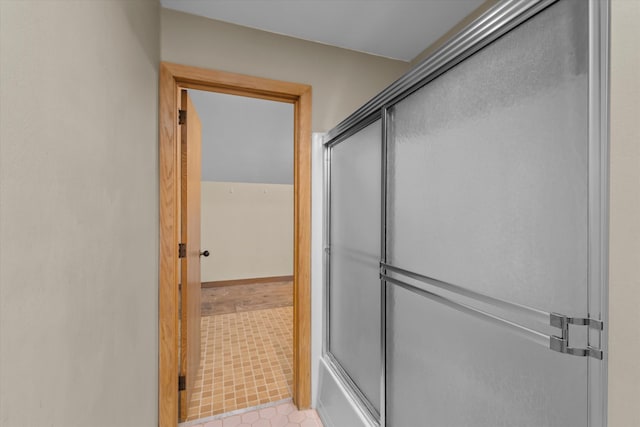 bathroom featuring shower / bath combination with glass door and tile patterned floors