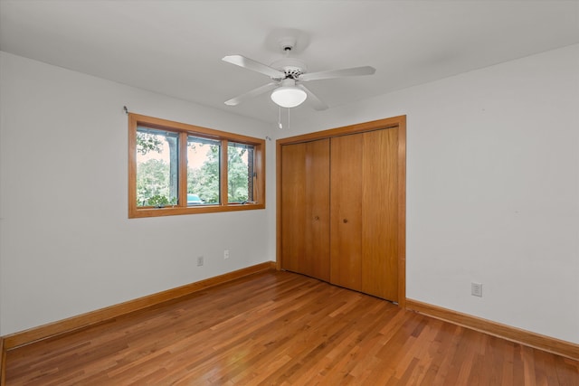 unfurnished bedroom featuring ceiling fan, light hardwood / wood-style floors, and a closet