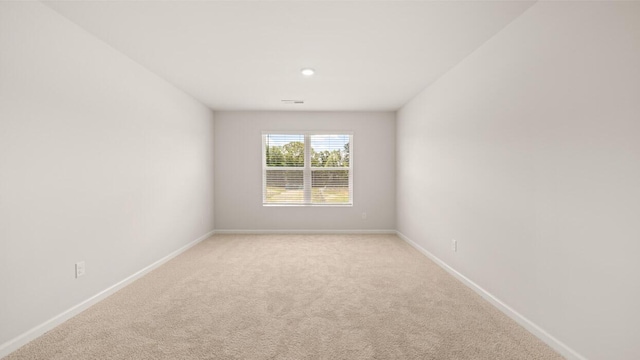 spare room featuring light colored carpet