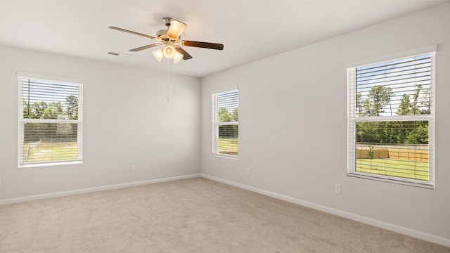 empty room with ceiling fan and light carpet