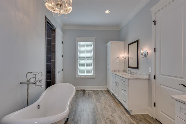 bathroom with ornamental molding, vanity, a bath, an inviting chandelier, and hardwood / wood-style floors