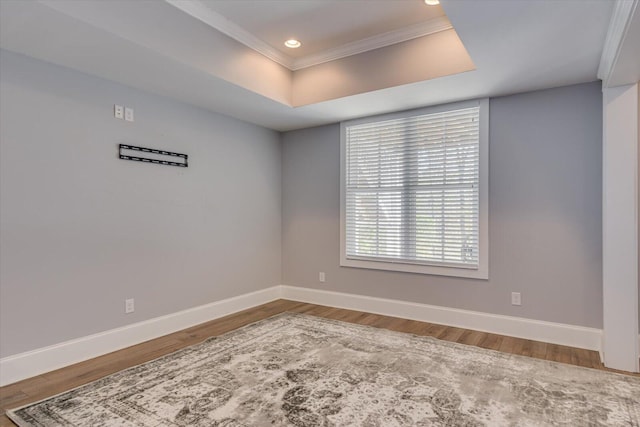 unfurnished room featuring hardwood / wood-style floors, ornamental molding, and a tray ceiling