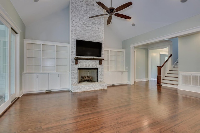 unfurnished living room featuring ceiling fan, lofted ceiling, a fireplace, and dark wood-type flooring