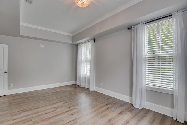 spare room featuring crown molding and light hardwood / wood-style flooring