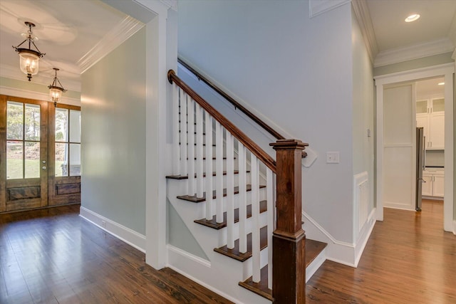 stairway with french doors, hardwood / wood-style flooring, and crown molding